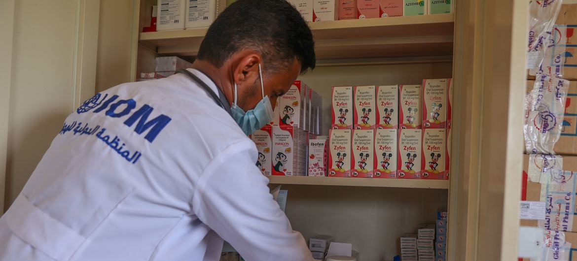 Um profissional de saúde apoiado pelo OIM no Iêmen acessa suprimentos médicos.