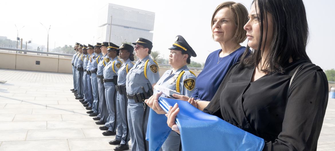 Protocolo da ONU e oficiais de segurança na cerimônia de hasteamento da bandeira.