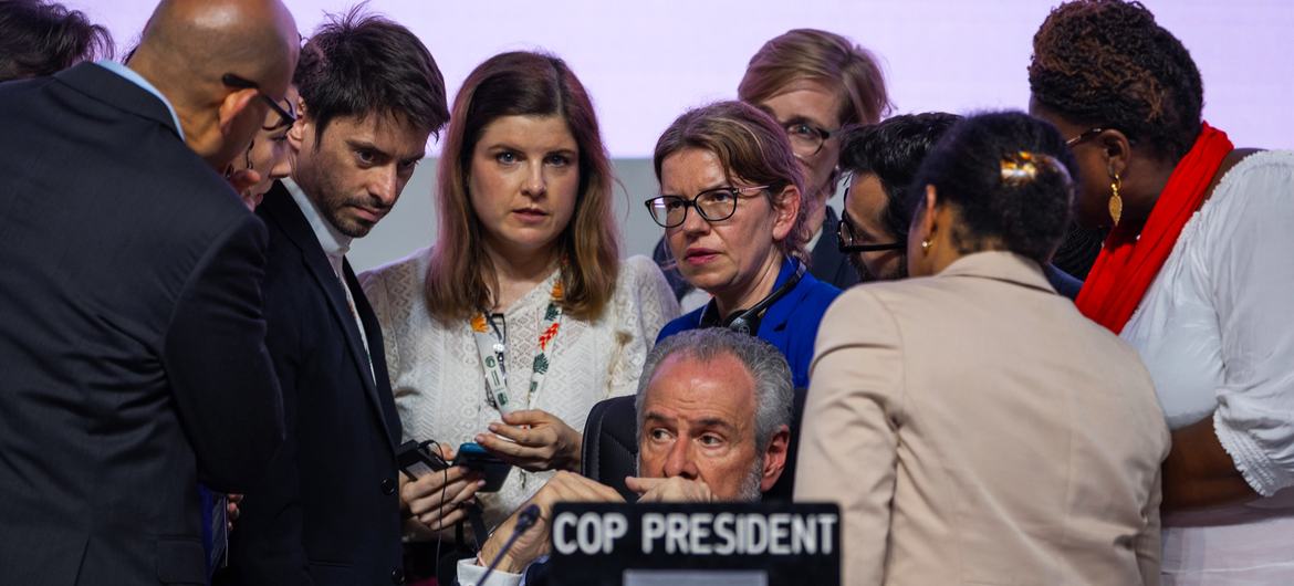 O presidente da COP30, André Corrêa do Lago (centro), conversa com sua equipe no encerramento da Conferência do Clima da ONU.