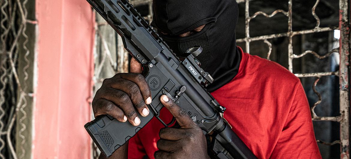 Um membro de uma gangue posa com um rifle de alto calibre no bairro Delmas 3, em Porto Príncipe.
