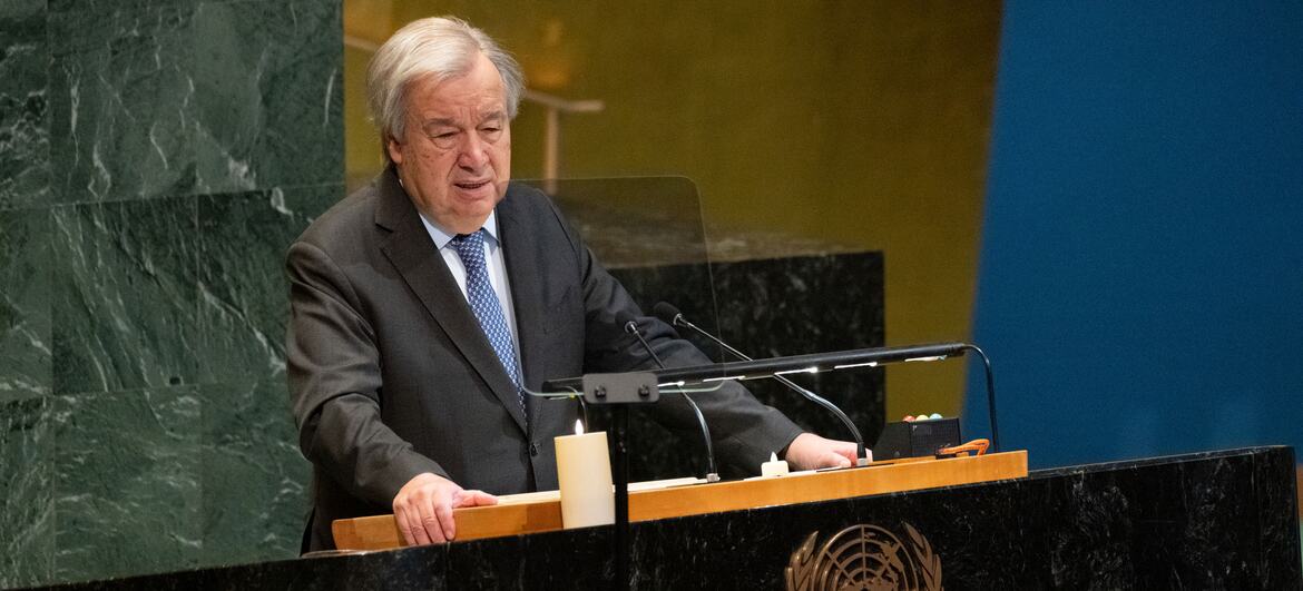 O Secretário-Geral António Guterres discursa na Cerimónia em Memória do Holocausto das Nações Unidas, num pódio com o emblema da ONU e uma vela.