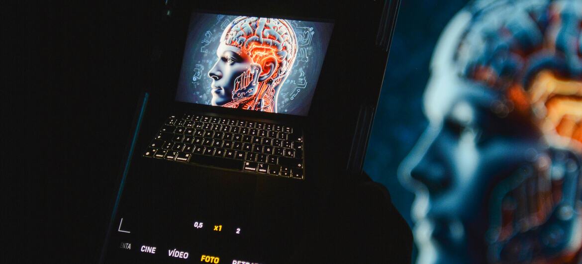 Um smartphone exibindo um cérebro digital na tela, colocado em cima de um laptop, simbolizando a inteligência artificial e a tecnologia da próxima geração.