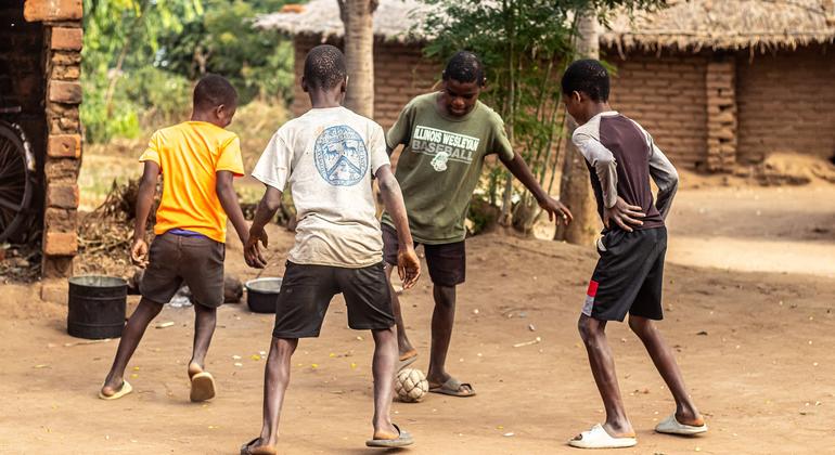 Bernard Daud (de camiseta verde) jogando futebol com seus amigos no complexo de Alesi Mitambo na vila de Chabwera, distrito de Chiradzulu